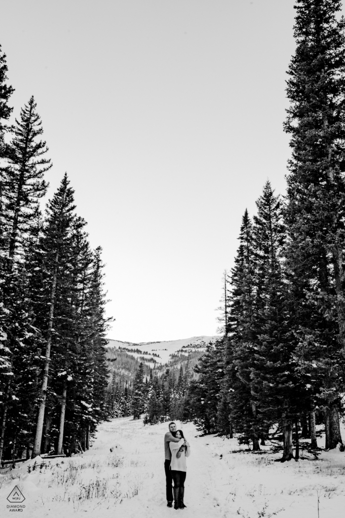 Photo by: <a href="https://www.wpja.com/photos/diamond-award-top-wedding-engagement-photographer/2422546">Michael Freas - Key West Florida engagement photo of couple between trees and snow | Rocky Mountain National Park, Estes Park, Colorado | photo after first snow