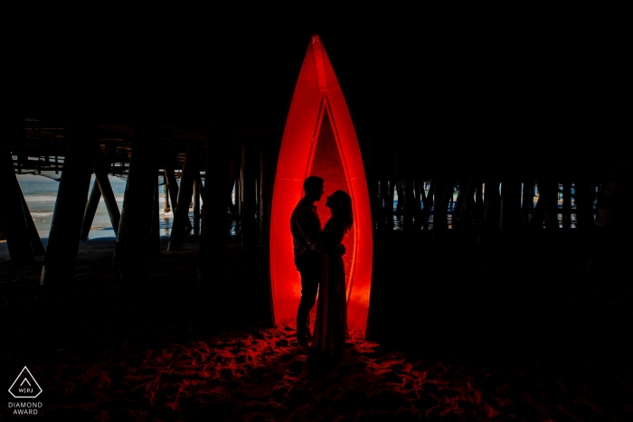 Silhouette rossa sotto il molo di Santa Monica | Fotografo del ritratto di fidanzamento della California