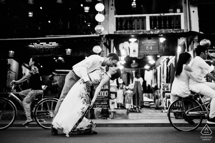 Dieses Verlobungsfoto wurde in Hoi An aufgenommen und zeigt ein Paar, das mit Fahrrädern durch die Straßen spaziert