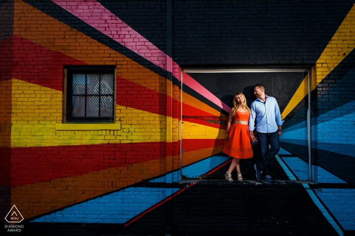 Denver, CO Retratos Pré-Casamento | Um casal compartilhando um momento em frente a um belo mural de arte no centro de Denver para sua sessão de noivado urbano.