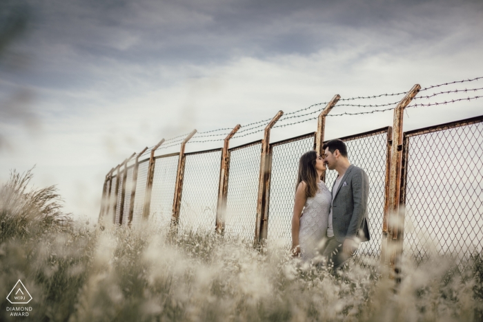 Photo by: <a href="https://www.wpja.com/photos/diamond-award-top-wedding-engagement-photographer/2424926">Emre Nesli - Mersin Mersin Love in front of the wire wall - Engagement Photograph with Barbed Wire topped Fence