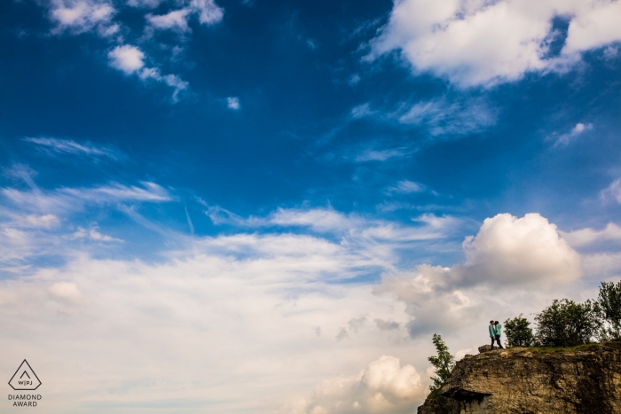 Brno Stránská skála fiancés sur une falaise surplombant un paysage rempli de nuages ​​et de ciel bleu