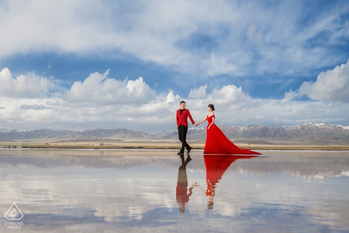 And engaged Chinese couple walk on a clouded mirage for their pre-wedding portrait