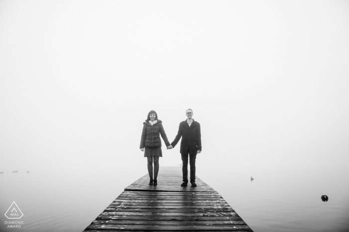 Amiens France, portrait de fiançailles d'un couple debout, épaules carrées, main dans la main sur un petit quai dans le brouillard