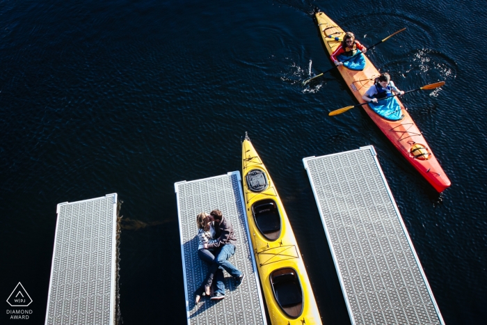  Engagement Session Puget Sound - Couple laying down kissing on dock in marina 