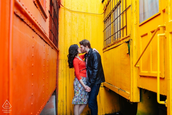 Creative Engagement Session Seattle - Bright colored trains surrounding kissing couple