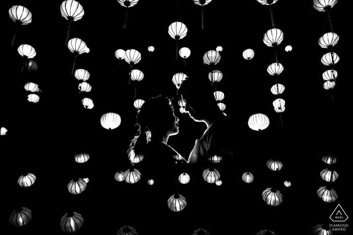 Photo by: <a href="https://www.wpja.com/photos/diamond-award-top-wedding-engagement-photographer/2429201">Lucas Tran - Hai Chau Da Nang Hoi An black-and-white and portrait of a couple face-to-face below hanging lanterns