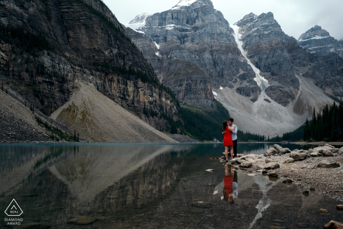 Foto door: <a href="https://www.wpja.com/photos/diamond-award-top-wedding-engagement-photographer/2426516"> Dorota Karpowicz - Edmonton Alberta Banff National Park engagement portret sessie over het meer met een rode jurk en reflecties