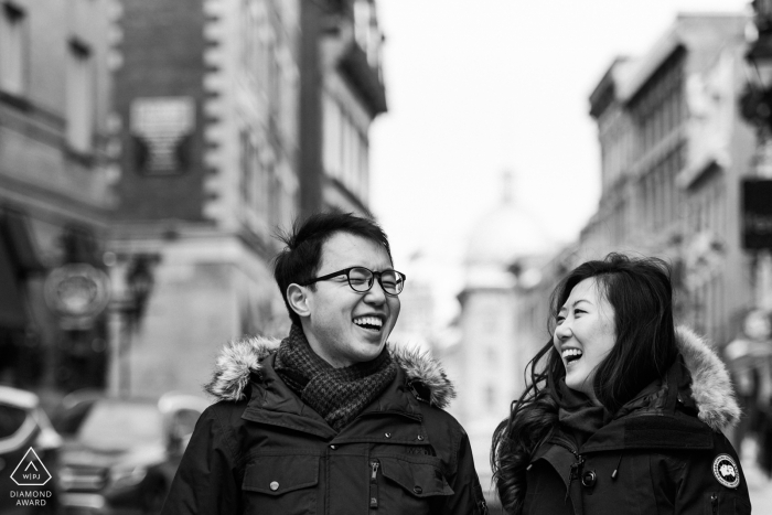 Photo de fiançailles en noir et blanc d'un couple qui rit dans le Vieux-Montréal - Séance de fiançailles d'hiver dans le Vieux-Montréal