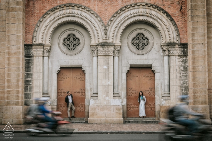 Foto: <a href="https://www.wpja.com/photos/diamond-award-top-wedding-engagement-photographer/2426746"> Raymond Nguyen - Sacramento, Kalifornien Sai Gon Verlobungsportrait eines Paares, das in separaten Türöffnungen steht, während Roller vorbeifahren
