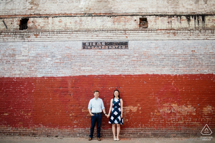 Photo by: <a href="https://www.wpja.com/photos/diamond-award-top-wedding-engagement-photographer/2429096">Kevin Trimmer - Providence Rhode Island couple in front of red brick wall - Rhode Island Engagement Photographer