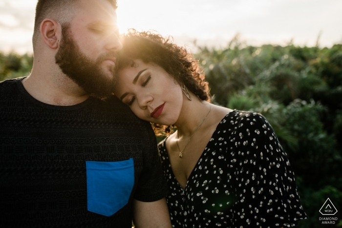 Rio de Janeiro couple embraced with her eyes closed in the warm afternoon sun for their pre-wedding portrait