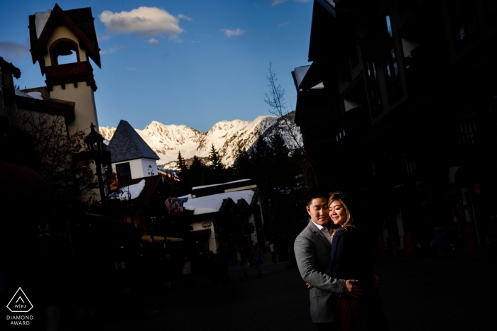 Verlobungsporträtshooting in der Innenstadt von Vail, Colorado, mit der Gore Range, die für die Sitzung dieses Paares von den letzten Lichtstrahlen erleuchtet wird.