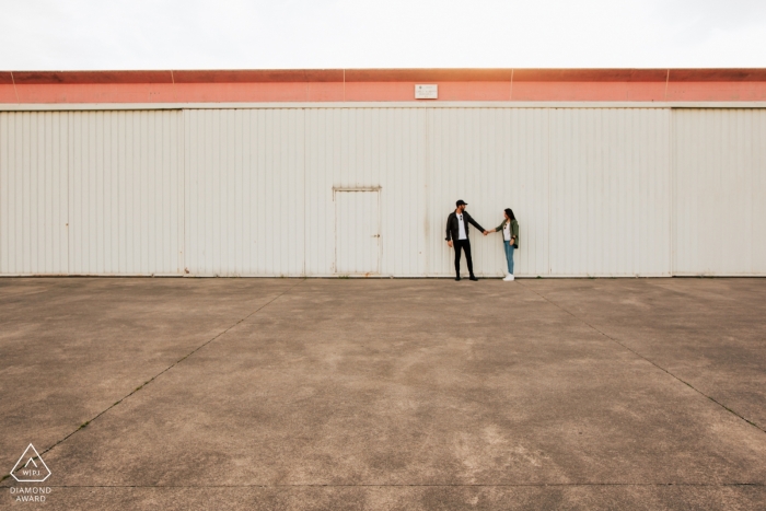Photo by: <a href="https://www.wpja.com/photos/diamond-award-top-wedding-engagement-photographer/2434921">Enrico Celotto - Mussolente Vicenza Vicenza Hangar engagement photos - couple holding Hands at the airport