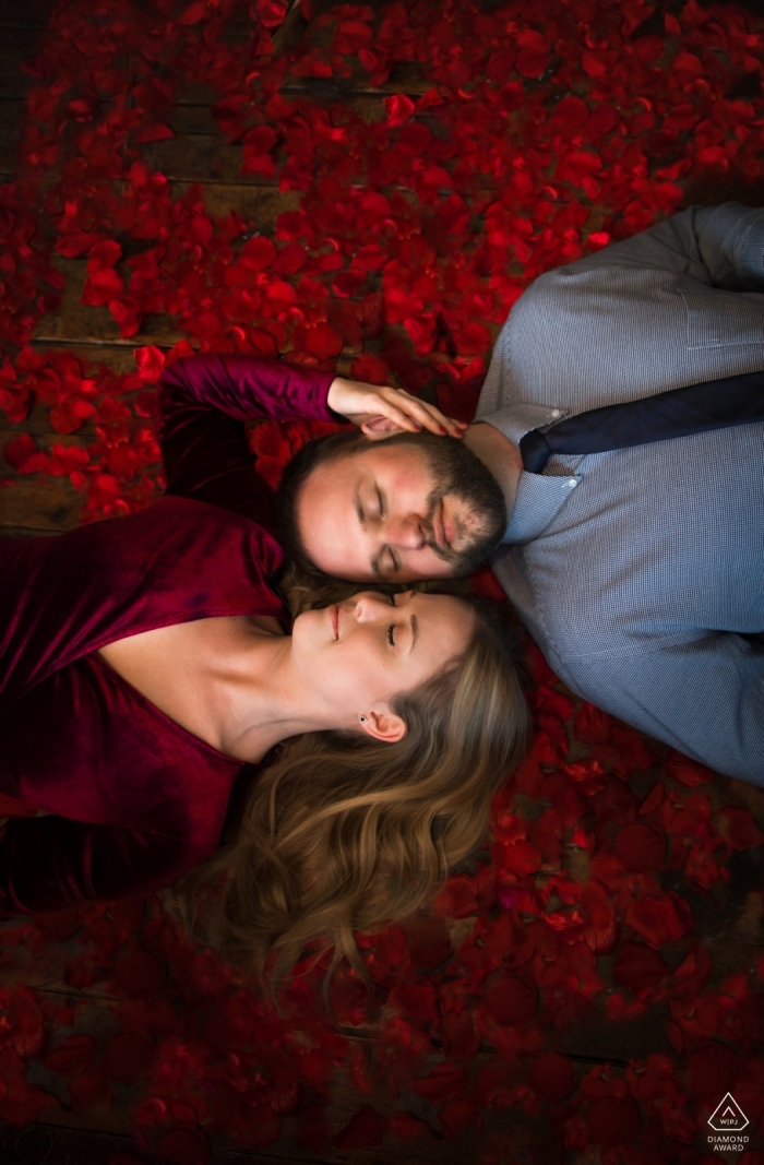 Photo by: <a href="https://www.wpja.com/photos/diamond-award-top-wedding-engagement-photographer/2452406">Adam Boole - St. Louis Park Minnesota Fargo, North Dakota engagement portrait session - couple relaxes together at Wild Terra Cider Bar surrounded by rose petals
