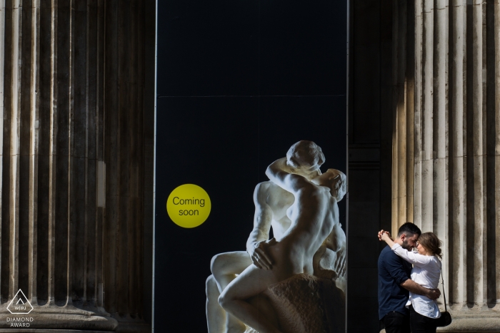 London, United Kingdom portraits for engaged Couple in front another greek couple sculpture 