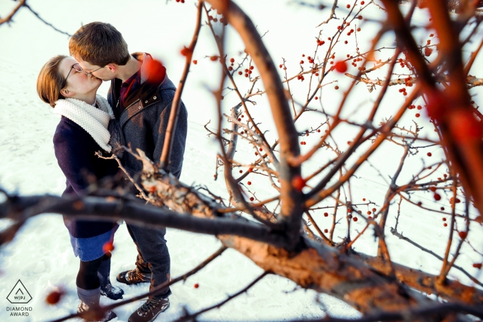 Photo: <a href="https://www.wpja.com/photos/diamond-award-top-wedding-engagement-photographer/2446921"> Ruthie Hauge - McFarland Wisconsin Tenney Park, Madison, Wisconsin portraits de pré-mariage | Les fiancés prennent un moment pour s’embrasser en marchant sur le brise-lames enneigé du lac Mendota.