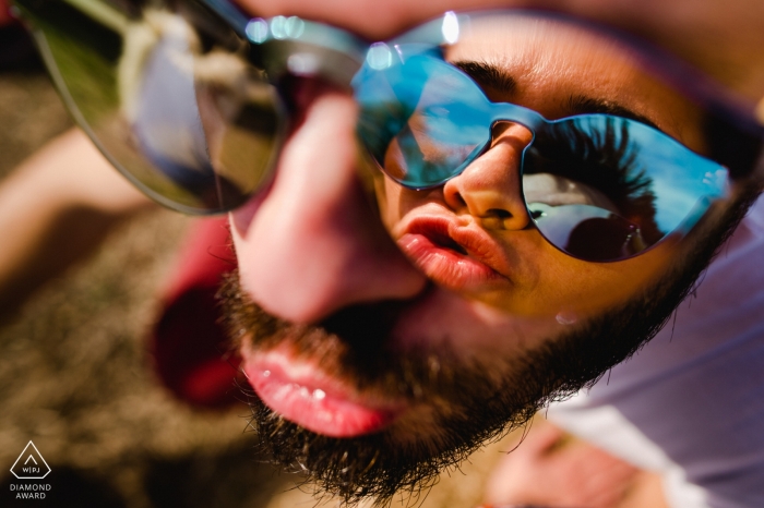 Retratos de compromiso en un parque infantil en Timisoara, Rumania | Reflejo de la novia en las gafas de sol.