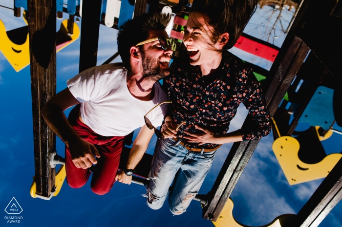 Playground in Timisoara, Romania pre-wedding portrait session | Hanging on the playground gears upside down. 