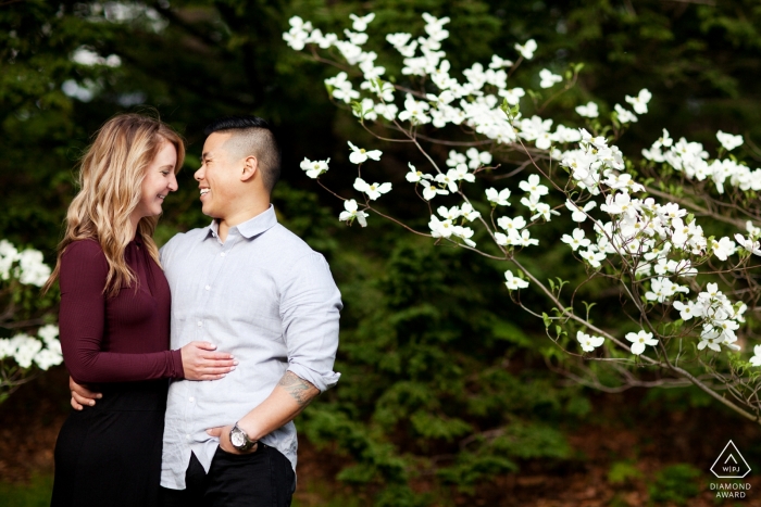 Photo by: <a href="https://www.wpja.com/photos/diamond-award-top-wedding-engagement-photographer/2452181">Kevin Trimmer - Providence Rhode Island Boston, Massachusetts Couple with flower tree in the park - engagement portrait session