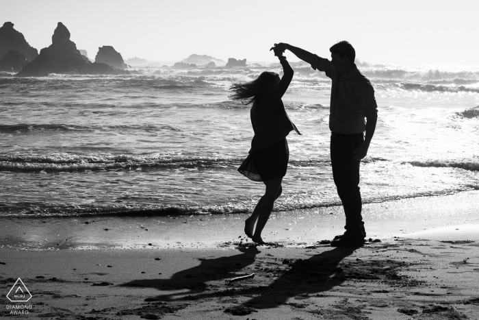 Jughandle State beach, Mendocino, CA portrait session - newly engaged couple dancing twirl on the beach