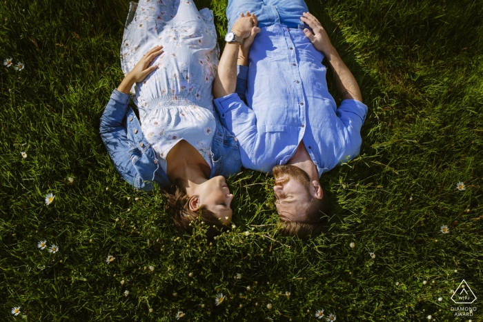 Verlobungsfotosession eines Paares, das auf einem Feld in Aachen liegt.