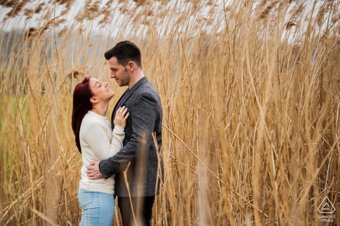 Foto: <a href="https://www.wpja.com/photos/diamond-award-top-wedding-engagement-photographer/2456166"> Jason Huckle - Rushden Northamptonshire Verlobungsporträt eines Paares, das sich hält, während sie in hohen Gräsern in Delapré Abbey, Northampton stehen.