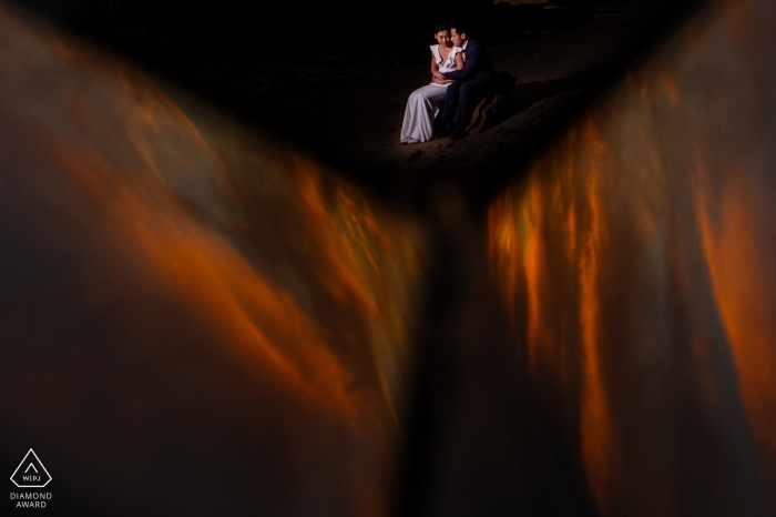 Engagement photo of a woman sitting on a man's lap in the distance in San Francisco.