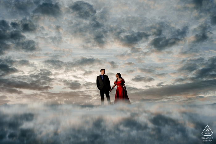 Foto de compromiso de una pareja hecha para parecer como si estuvieran de pie en las nubes en San Francisco.