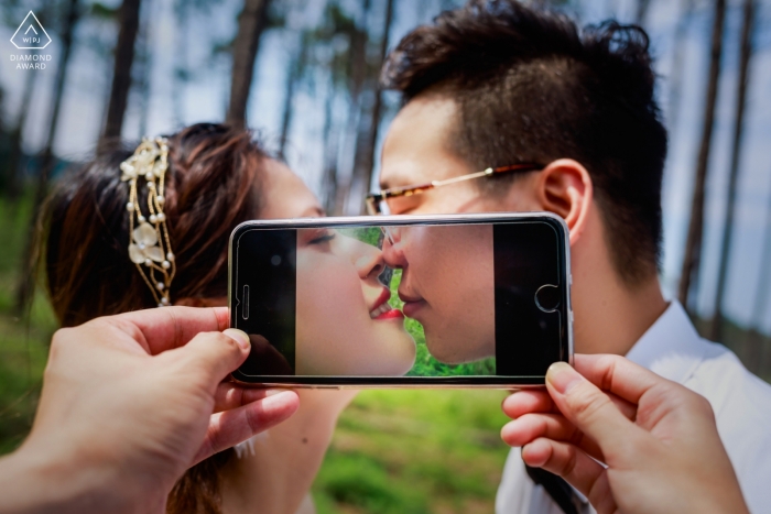 Photo by: <a href="https://www.wpja.com/photos/diamond-award-top-wedding-engagement-photographer/2456971">Henry Xu - Fuzhou CHANG LE SEASORE WOODS ENGAGEMENT PORTRAIT - Their kissing in the phone