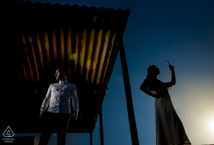 Séance photo de fiançailles d'un couple debout à l'extérieur au crépuscule à Cabo de Gata.