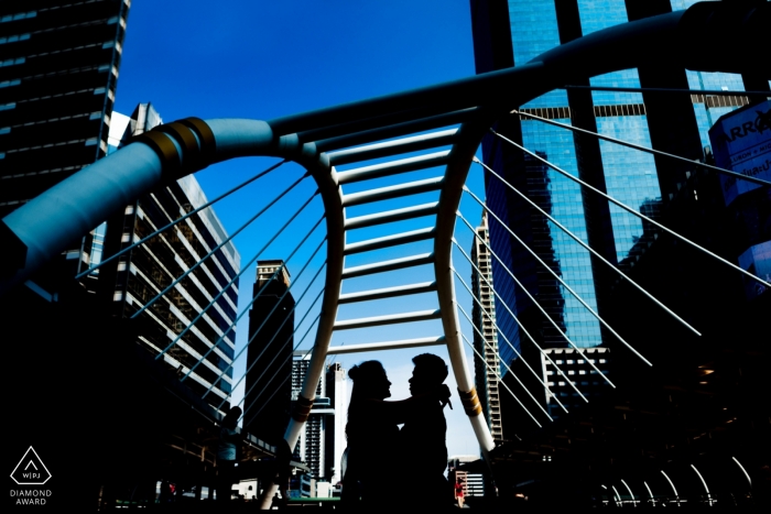 Pre-wedding photo session of the couple standing on a bridge in Bangkok.