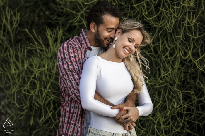 Photo by: <a href="https://www.wpja.com/photos/diamond-award-top-wedding-engagement-photographer/2461071">Clara Sampaio - Rio de Janeiro Rio de Janeiro Engagement session of the groom hugging the bride by the greenery in Rio de Janeiro, Brazil.