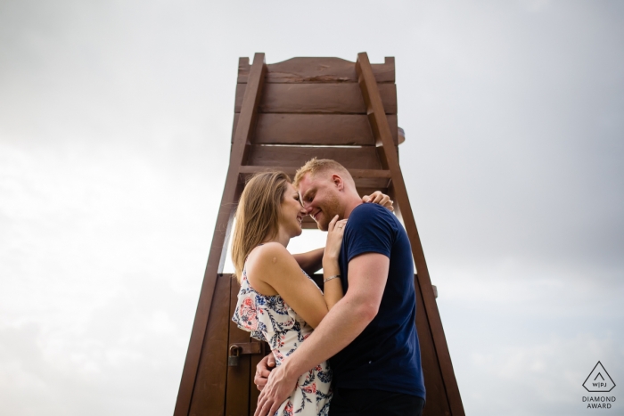 Photo by: <a href="https://www.wpja.com/photos/diamond-award-top-wedding-engagement-photographer/2467021">Alan Fresnel - Playa del Carmen Quintana Roo Couple kiss behind a lifeguard stand in this Playa del Carmen engagement photo shoot