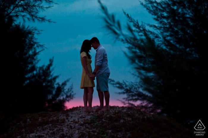 Photo by: <a href="https://www.wpja.com/photos/diamond-award-top-wedding-engagement-photographer/2468091">Chin Whei Tay - Malacca Couple hold hands in front of a beautiful dusk sky in this Malaysia pre-wedding shoot