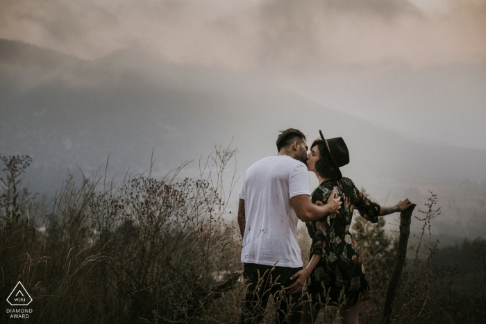 A couple kiss in the middle of a field on a foggy day during this Istanbul engagement shoot