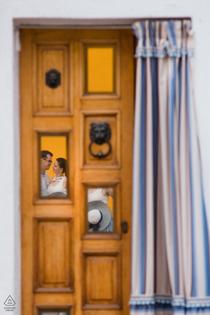Photo by: <a href="https://www.wpja.com/photos/diamond-award-top-wedding-engagement-photographer/2472276">Lubow Polyanska - Prague In this Czech Republic engagement photography session, the photographer captures the couple through reflections in an old yellow door