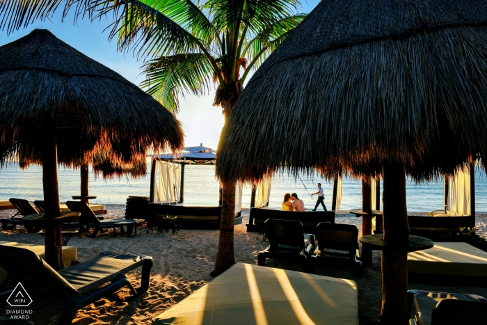 Playa del Carmen, Messico - la coppia osserva il sorgere del sole su una spiaggia piena di capanne vuote in questa sessione fotografica di fidanzamento