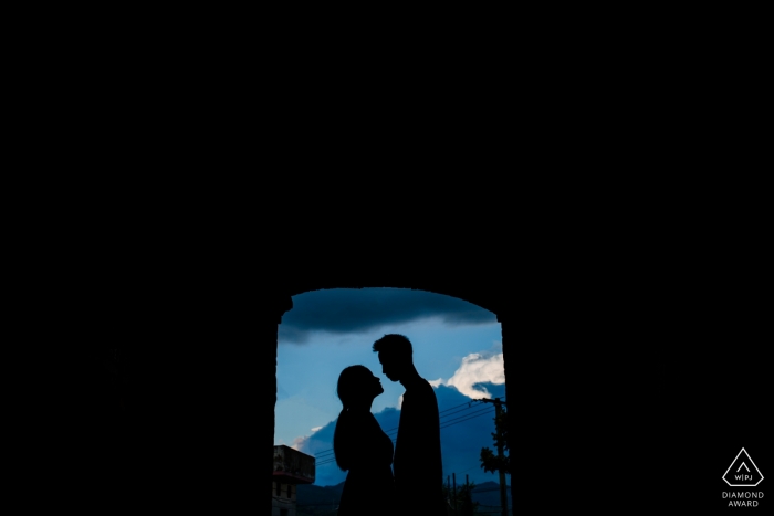Photo by: <a href="https://www.wpja.com/photos/diamond-award-top-wedding-engagement-photographer/2475811">Joy Qin - Longyan The silhouettes of the couple standing in front of an open doorway with mountains in the distance were captured in this Fujian, China pre-wedding portrait session