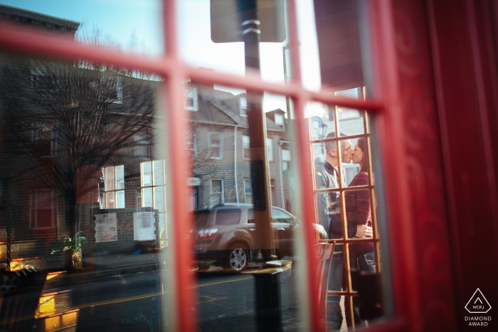 Séance photo de fiançailles à Baltimore, dans le Maryland - Un couple baise une vieille cabine téléphonique