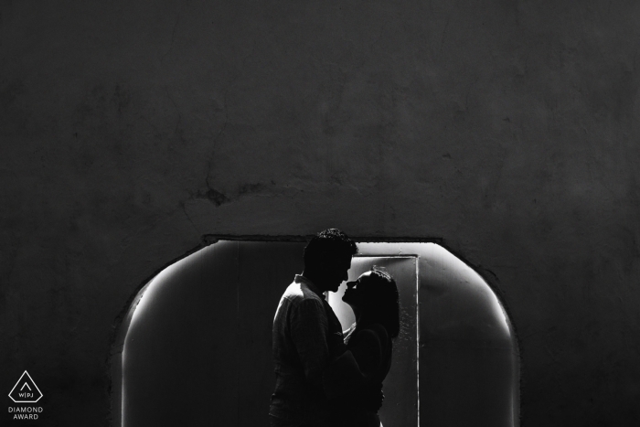 Le couple se tient dans cette photo de fiançailles en noir et blanc devant le Fort de Galle. Prise par un photographe du Sri Lanka à Galle.