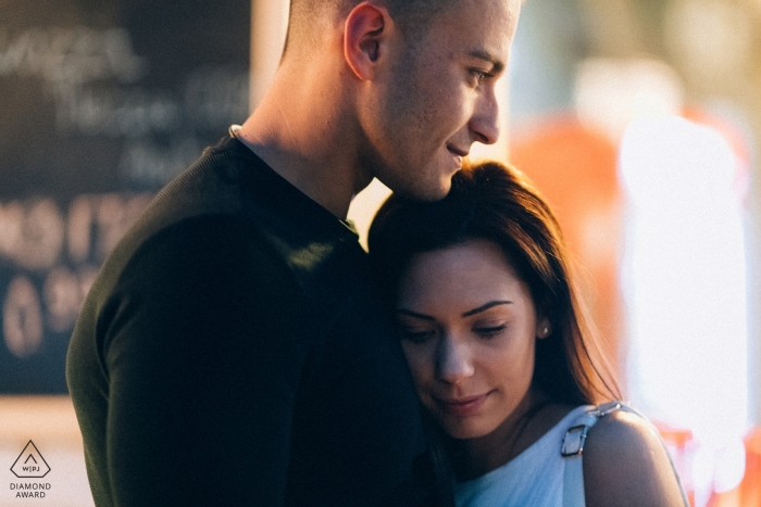 Photo by: <a href="https://www.wpja.com/photos/diamond-award-top-wedding-engagement-photographer/2479556">Bozhidar Krastev - Ruse A couple stands together in a cafe in Ruse in this nighttime engagement portrait by a Bulgaria photographer.