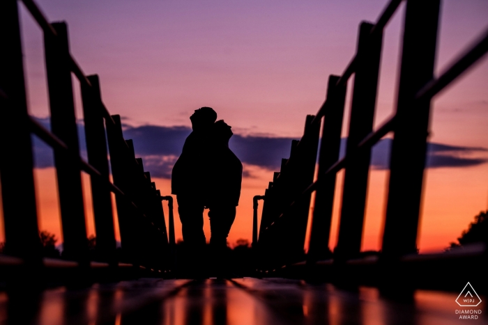 Un couple se tient dos à dos au coucher du soleil lors de cette séance de fiançailles à Arlesey, réalisée par un photographe du Bedfordshire, en Angleterre.