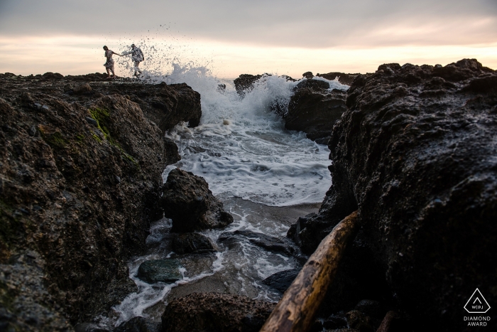 Laguna Beach, CA engagede couple taking a walk on the rocks at Laguna Beach.