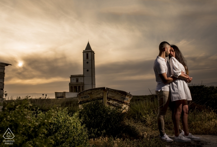 A couple stands in front of the Cabo de Gata as the sun sets in this engagement photo by a Murcia, Spain photographer.