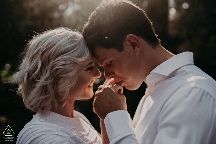 In San Francisco, a man kisses his fiance's hand during their engagement session by a Sacramento, CA photographer.