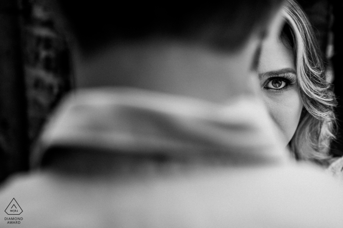 In Vitoria, half of a woman's face can be seen as her fiance stands in the foreground in this black and white engagement photo by a Rio Grande do Sul, Brazil photographer. In Vitoria, half of a woman's face can be seen as her fiance stands in the foreground in this black and white engagement photo by a Rio Grande do Sul, Brazil photographer.