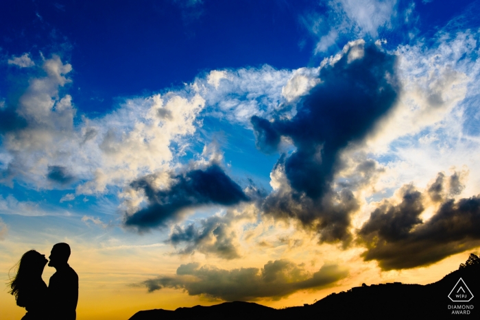 Die Silhouette eines Paares in Lavras Novas kann vor dem Hintergrund eines strahlenden Himmels in dieser Vorhochzeitssitzung von einem Fotografen aus Minas Gerais, Brasilien, gesehen werden.