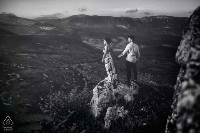 Photo: <a href="https://www.wpja.com/photos/diamond-award-top-wedding-engagement-photographer/2496261"> Paolo Ferrera - Alvito Frosinone Un couple tient la main alors qu’il se tient sur un rocher à Rocca Calascio, surplombant les plaines, lors de cette séance de fiançailles animée par un photographe de Lazio, en Italie.