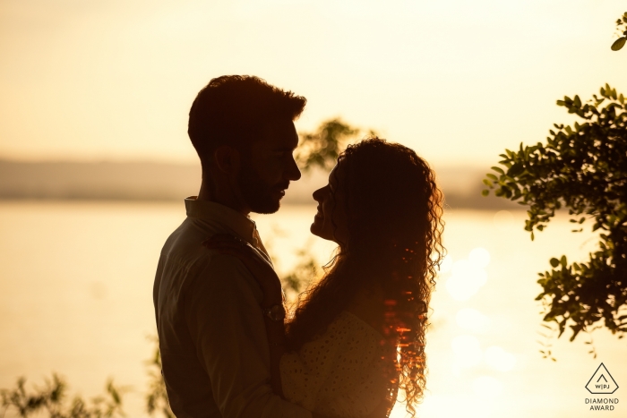 Photo by: <a href="https://www.wpja.com/photos/diamond-award-top-wedding-engagement-photographer/2497181">Massimiliano Esposito - Orvieto Terni A couple stands in the golden sunlight of Bolsena, Italy in this engagement photo by a Orvieto photographer.